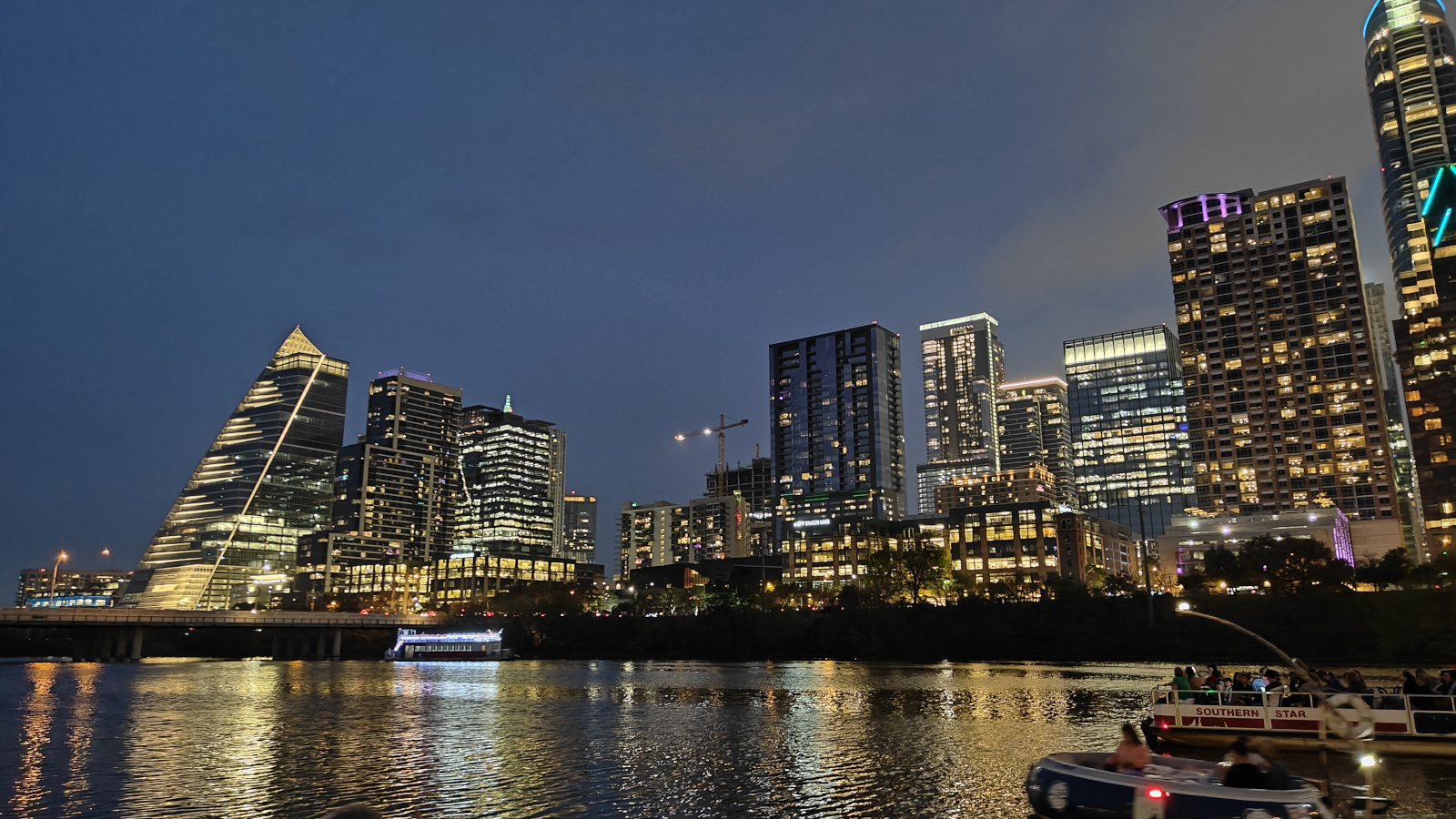 Scenic nighttime view of the Colorado River/Lady Bird Lake in Austin, with reflections of city lights on the water, illustrating the natural beauty near Zeta House